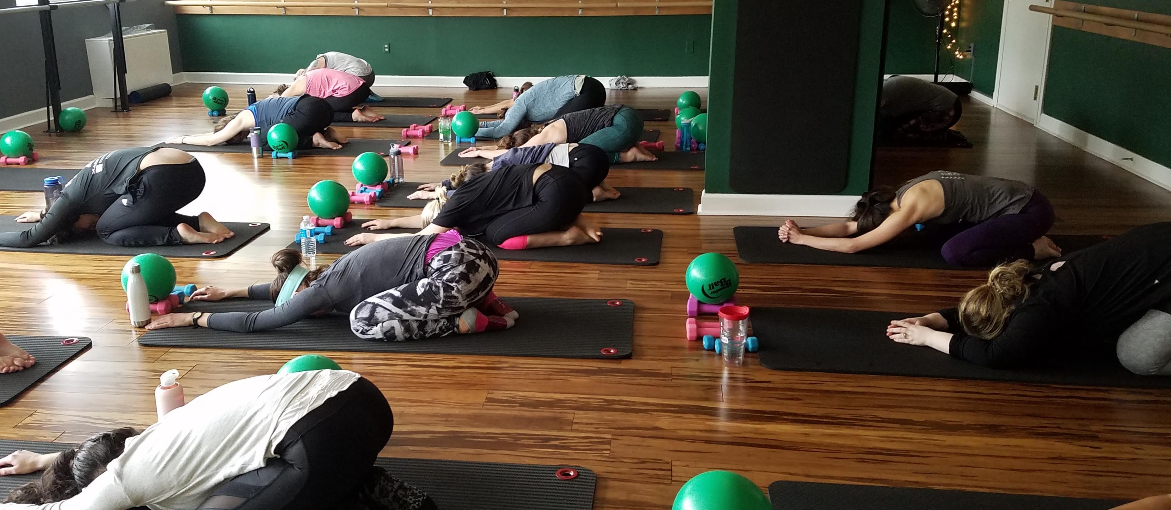 group of women in resting yoga stretch childs pose