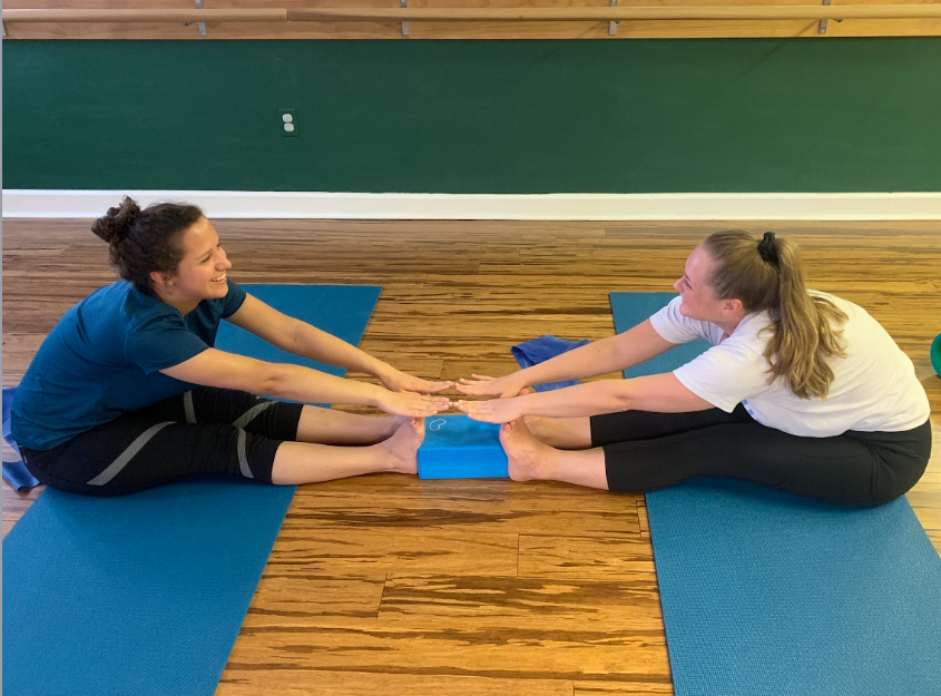 women in barre stretch class using yoga block to stretch muscles on balanced body yoga mats