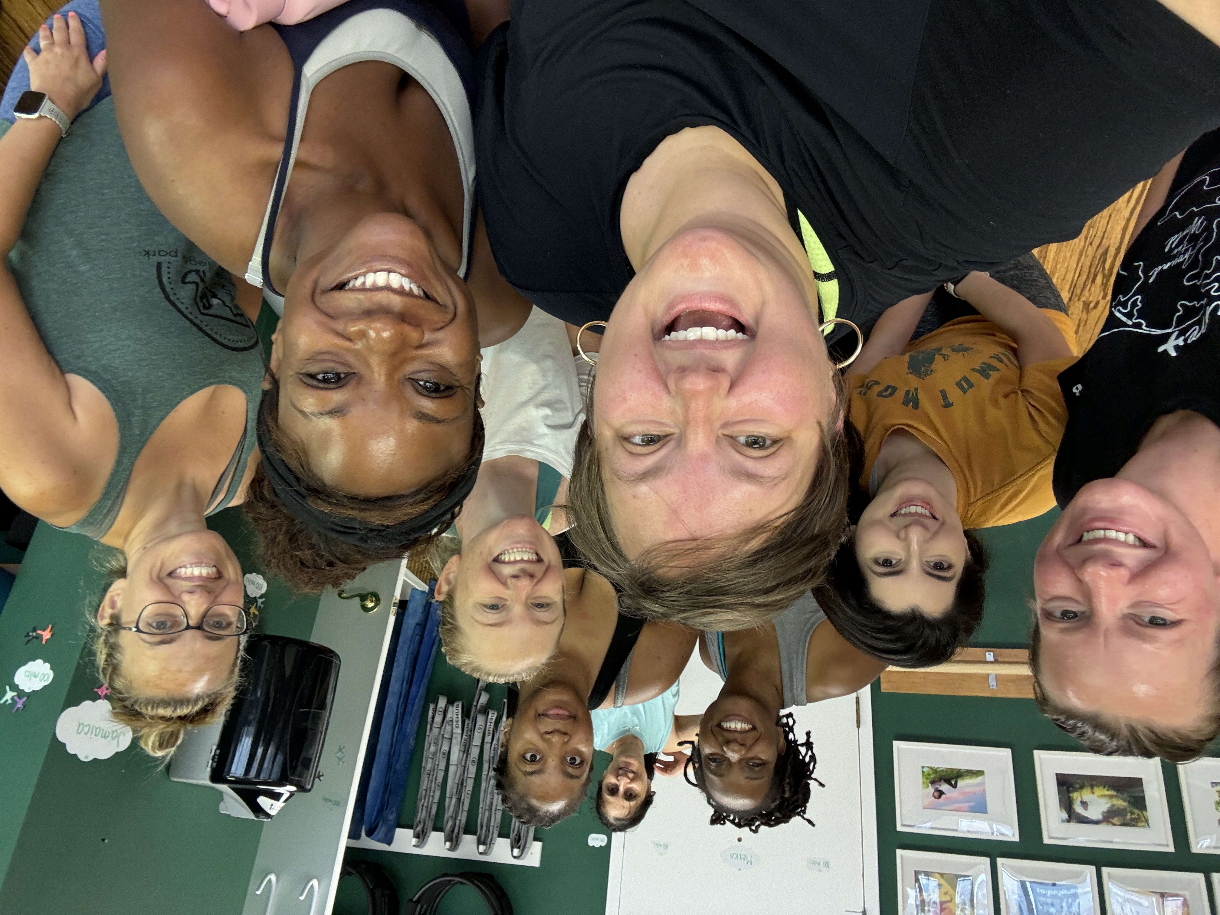 Nine women standing in a group smiling after a barre workout class